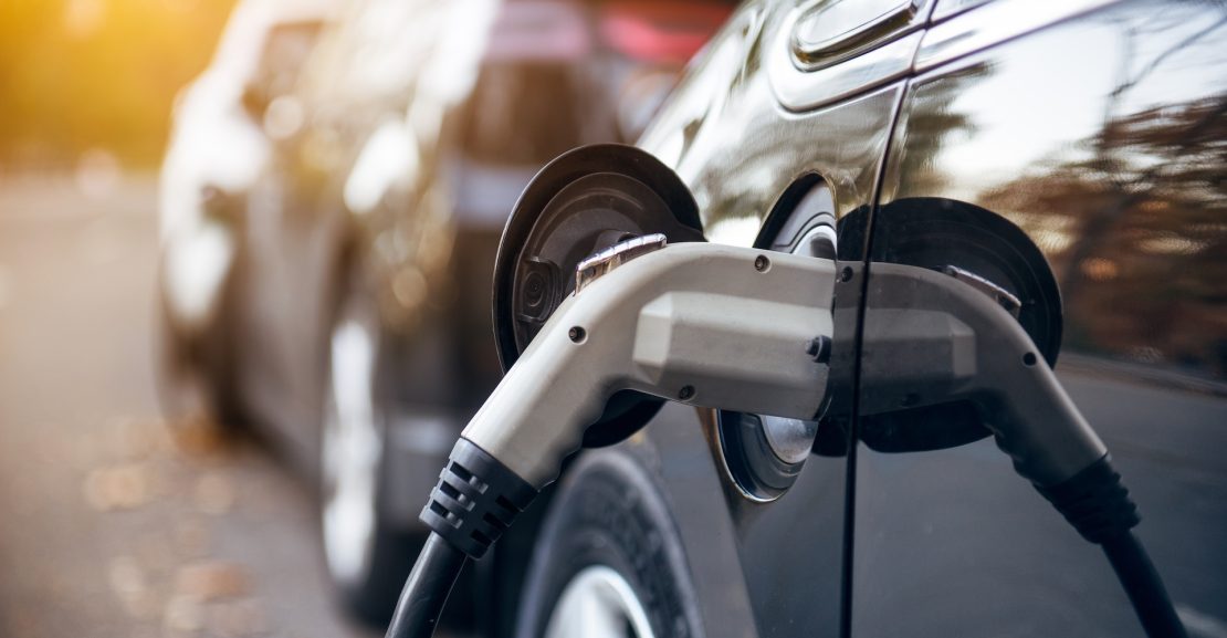 Kraunamas juodas elektromobilis (Shutterstock nuotr.)