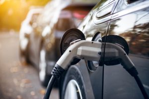 Kraunamas juodas elektromobilis (Shutterstock nuotr.)